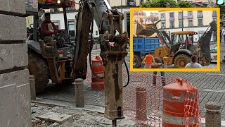 John Deere 310L backhoe breaking up Sidewalk with hammer and loading dump trucks with debris 