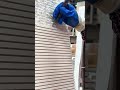 using a brush to carefully clean away dust from the detailed grooves of a textured decorative wall