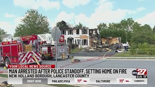 Man arrested after police standoff, setting home on fire