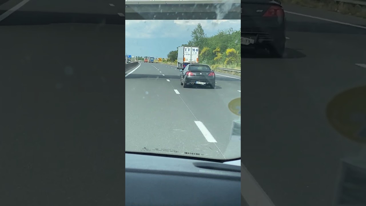 Driver on Highway with Licence Plate about to Fall