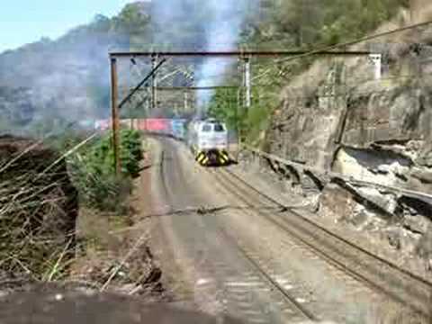 NOHAB-built, former Danish State Railways (DSB), GM-powered diesel locomotive conducting load trials with a scheduled container goods train on the steep gradients of Cowan Bank near Hawkesbury River, north of Sydney, NSW, Australia. 11-Oct-06. The train locomotive, Goodwin-Alco built 4497 and the rear 'banking' locomotive, Goninan-built 4717, were not providing power during this load trial. THIS IS THE EDITED VERSION. A lower-quality un-edited version of this clip is also uploaded (in MPEG).