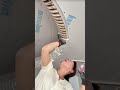 the process of installing flexible board pieces on a wooden frame on the ceiling of a building