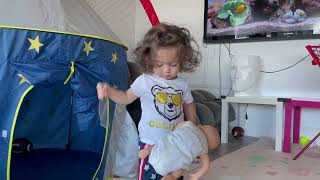 Little boy puts doll's arm on batting tee then hits it with a plastic baseball bat