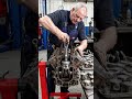 Mechanic dismantling the engine piece by piece, removing pistons