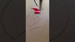 Red pigment fills flame outline on neutral fabric