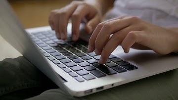 close up of female hands typing on the laptop keyboard