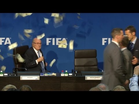 Comedian throws money at Blatter during press conference