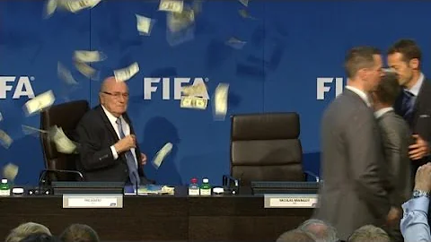 Comedian throws money at Blatter during press conf...