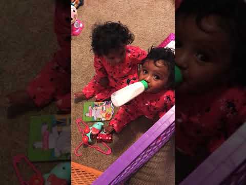 Twin girls fight over bottle, and yes her other sister have had her bottle already!!