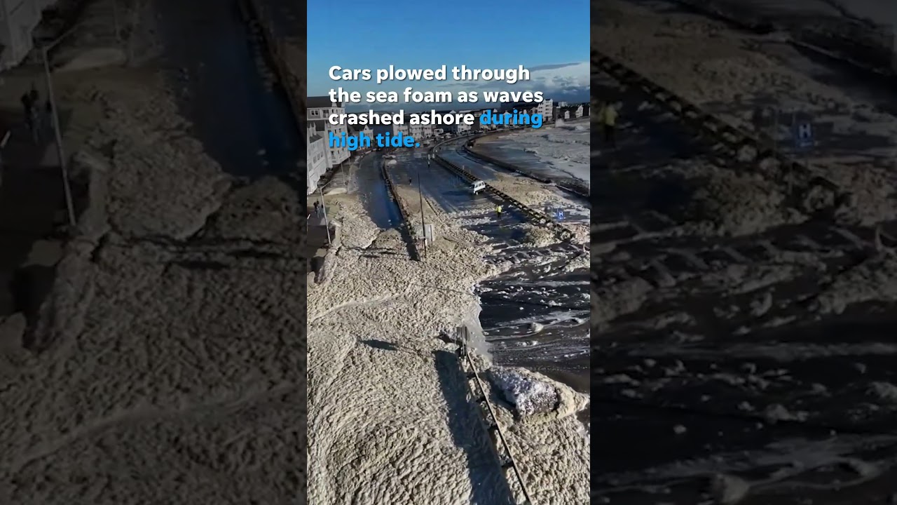 Cars navigate flooded road covered in sea foam after storm #Shorts