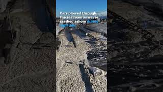 Cars navigate flooded road covered in sea foam after storm #Shorts