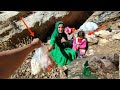 Under the big rock mother and child struggle for safety cameramans support