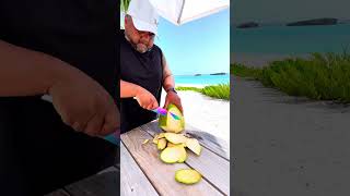 Cutting a fresh coconut on the beach in Exuma Bahamas