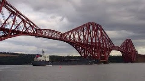 Autumn Cargo Ship Sailing Under Forth Railway Bridge On History Visit To Firth Of Forth Scotland