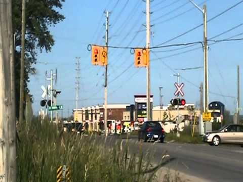 GO Transit Train 630 (cab 201) speeds Northbound towards the Barrie South GO Station through Barclay, near Alcona at mile 55.55 of the CN Newmarket Sub. This train is the 6:15pm arrival at Barrie South. Horrible horn on the cab leading this train... Made me cringe a bit.. Nifty crossing setup they have here though! This street is usually very busy, so its a nice addition to the crossing, to provide extra safety. If anyone knows the GO Transit frequencies for scanners on the BARRIE line, near Barrie, can you let me know?? Thanks a bunch!!