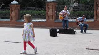 Девочка кружится под музыку гитаристов у Третьяковки