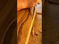 carving intricate wavy patterns into a wooden surface using a sharp gouge to create a unique texture