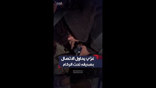 شاب غزّي يحاول الاتصال بصديقه بعد أن دُمر منزله وعلق تحت الركام