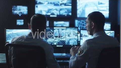 Two Security Officers are Working in a Dark Monitoring Room Filled with | VideoHive 14740947