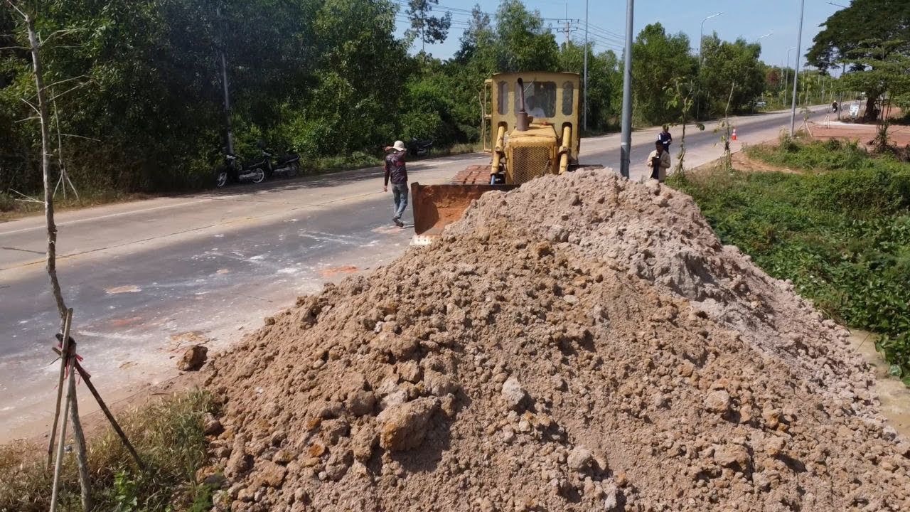 Processing Landfill by skill old CATERPILLAR dozer push soil cleaning forest side road, 5t truck 