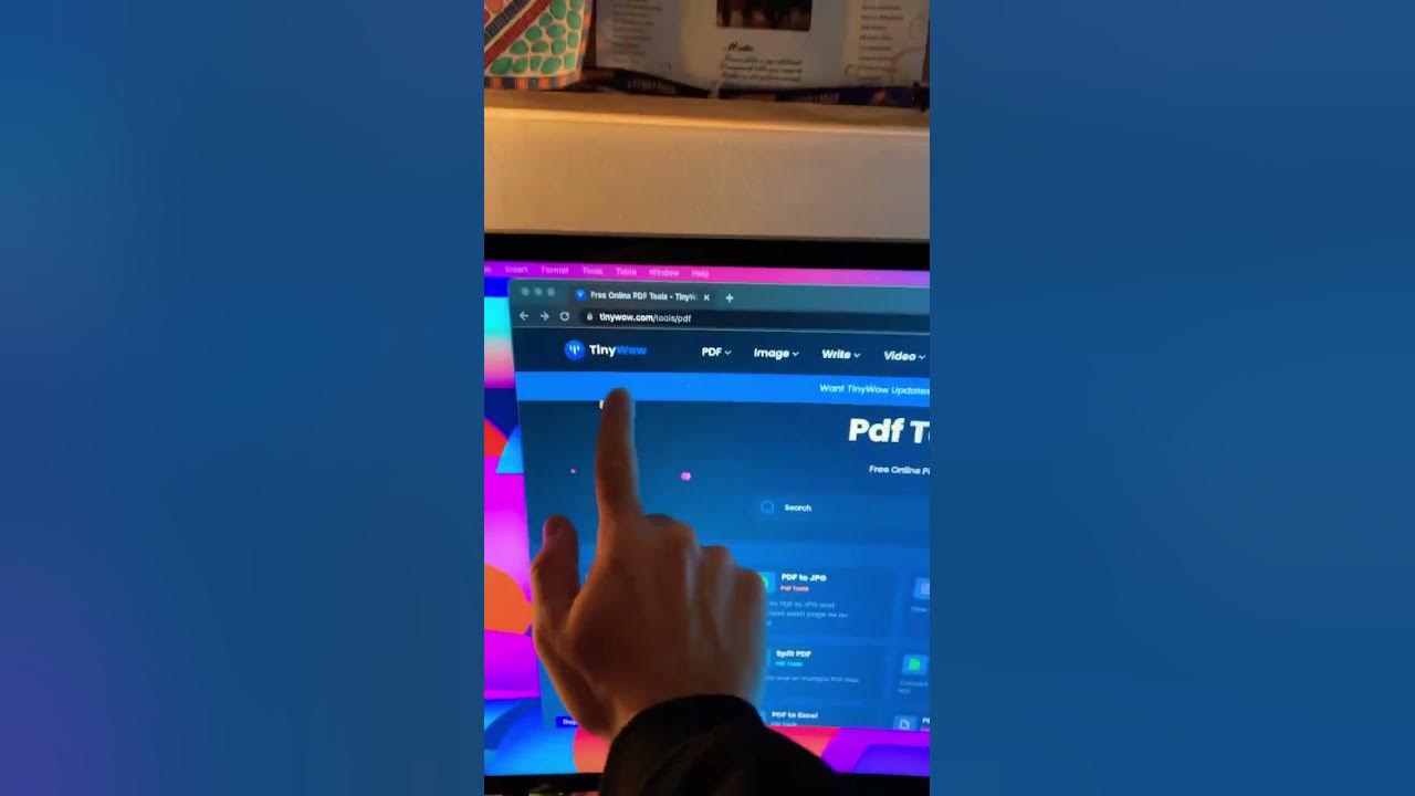  A person is using a laptop to convert a Word document to PDF using the website TinyWow.