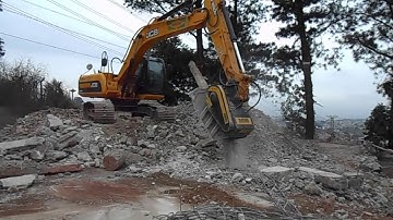 MB crusher bucket crushing concrete pile and railways sleepers