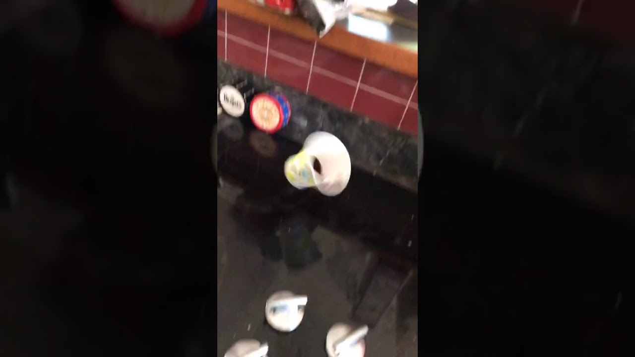 Person puts chocolate syrup in the bottom of a cup and throws it, it