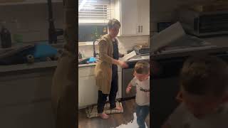 Boy walks over spilled milk on kitchen floor then slips and falls on his back