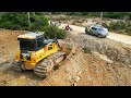 Full action project land filling up  bulldozer shantui pushing stone and dump truck unloading dirt