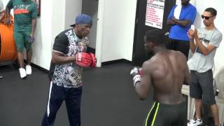 Andrew Tabiti and Floyd Mayweather working pads inside the Mayweather Boxing Club