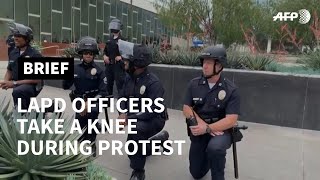 Los Angeles officers take a knee during George Floyd protest | AFP Los Angeles police officers take a knee in solidarity with protesters who are demonstrating following the killing of African American George Floyd who died after ..., From YouTubeVideos