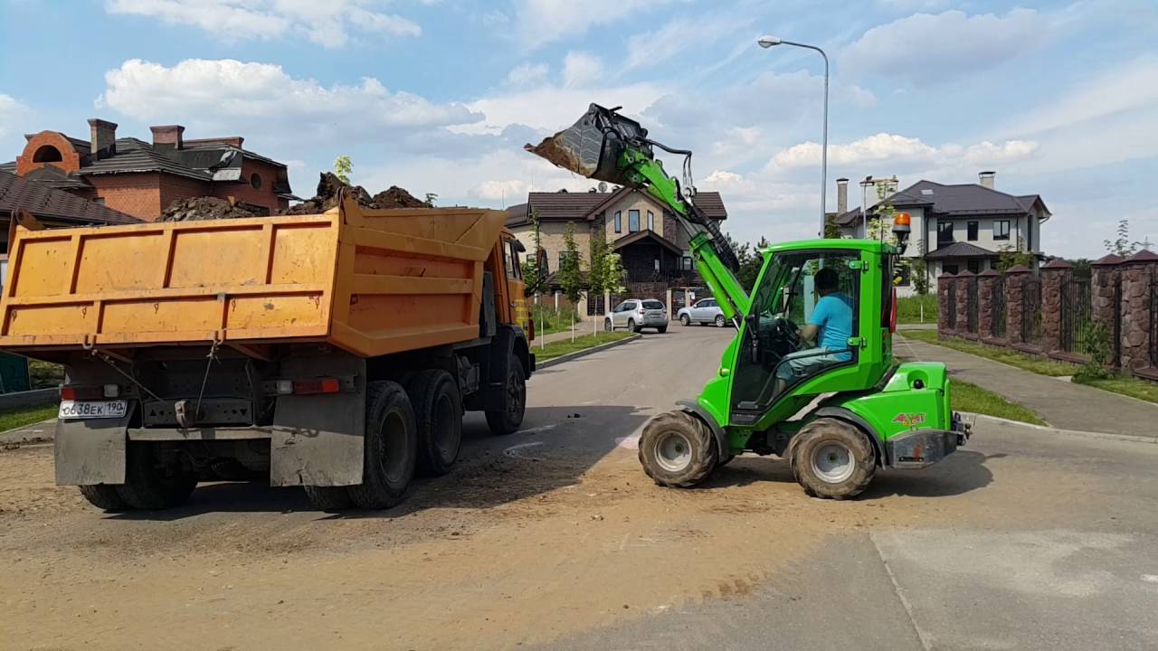 Трактора грузят. Bobcat погрузчик грузит самосвал. Экскаватор погрузчик грузит самосвал. Экскаватор грузит самосвал. Мини погрузчик грузит самосвал.