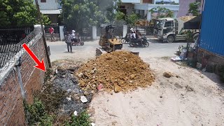 Up foundation house process by Komatsu dozer with dump trucks unloading use stone delete grass