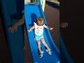 Ömür parkta  mavi kaydırağa biniyor.