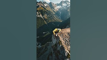 A giant excavator positioned on a perfectly cut, terraced stone quarry
