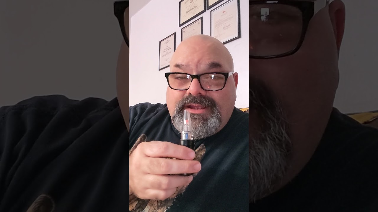 showing off a small vape pen device. The Flying Monkey XMAX.