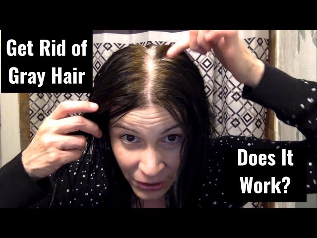 A woman with dark hair showing her grey roots before trying a can coffee color gray hair treatment