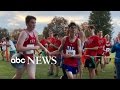 High school runner helps fellow runner finish at meet