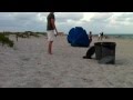 beach family ignores flying umbrella