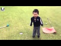 Little boy playing golf and getting very mad