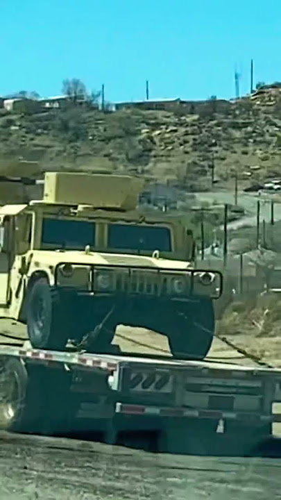 Couple of Military Humvee Vehicles on the Semi Trailer Truck on side of the road
