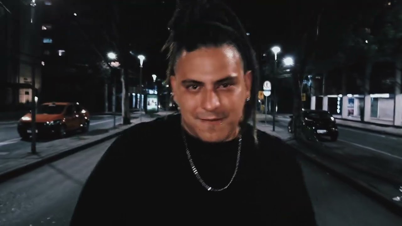 Homem caminhando sozinho à noite em uma rua vazia, segurando um copo, com iluminação urbana e estética minimalista.