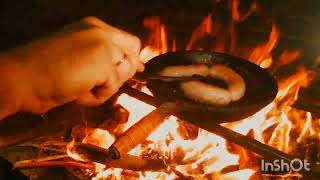 Dad and son are cooking dinner on the fire