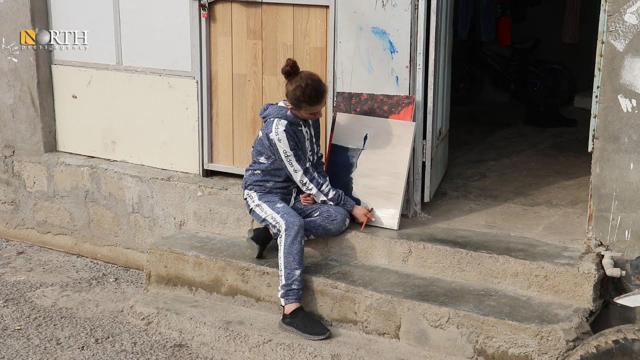 إيفا حاجو لاجئة سورية ترسم لوحة في منزلها بمخيم قوشتبه بمدينة أربيل