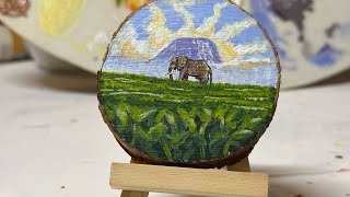 "Miniature Canvas: Majestic Landscape with a Central Elephant"