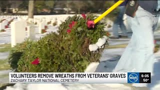 Volunteers help remove wreaths from veteran’s graves