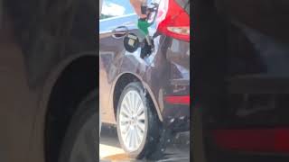 Guy fills his car up with gas at the pump
