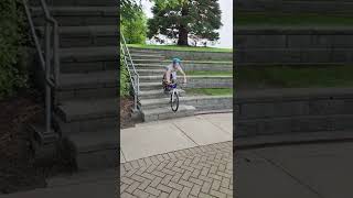Boy rides bike down stairs then falls forward over handlebar and faceplants