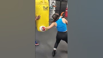 Floyd Mayweather Sr. instructs young lady on heavy bag