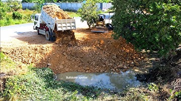 Nicely landfill Small project by dump truck unloading soil with mini bulldozer working push soil 